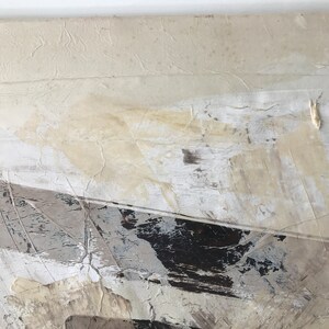 Op de afbeelding: Abstract schilderij met witte, grijze en zwarte verfstreken. Het schilderij heeft een textuur en een moderne stijl.