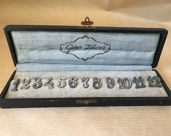 Set of 12 numbers to attach to clothing, silver metal Gero zilver