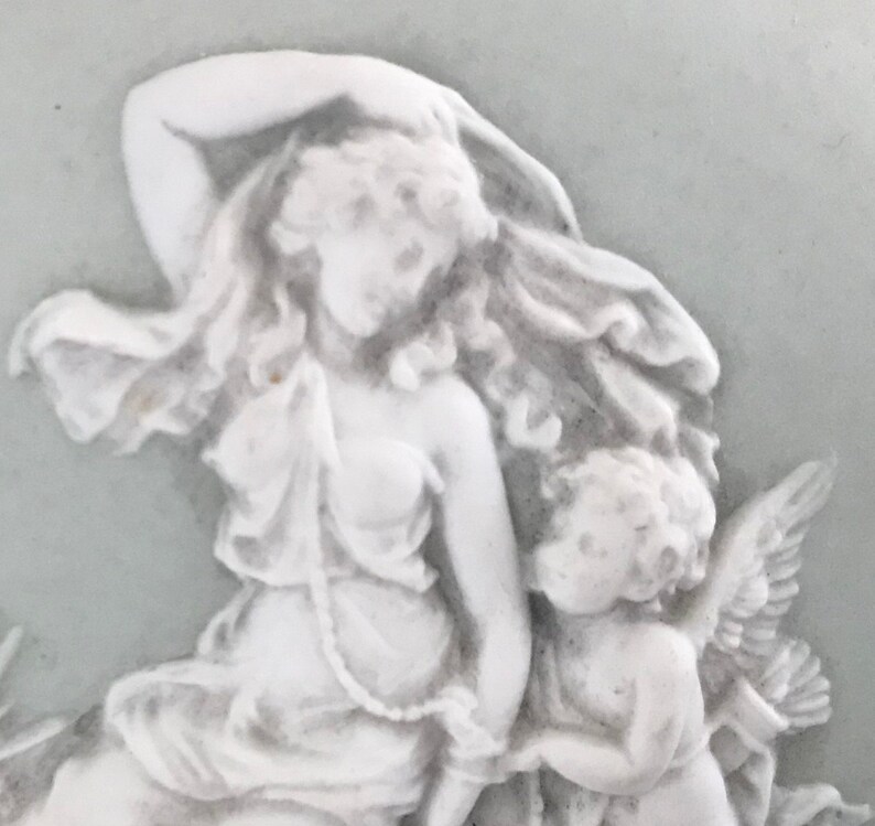 probably Wedgwood Small round green china plate with antique decor of a woman with angel