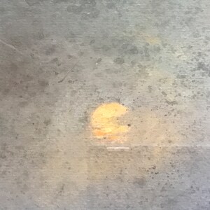 May include: A blurry, out-of-focus image of a sunset through a window with a textured glass surface.