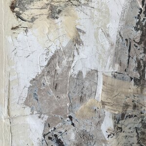 Op de afbeelding: Abstract schilderij met een textuur, gelaagde oppervlak. Het schilderij heeft tinten wit, grijs en beige met hints van zwart. De verf is aangebracht in een dikke, impasto-stijl, waardoor een driedimensionaal effect ontstaat.