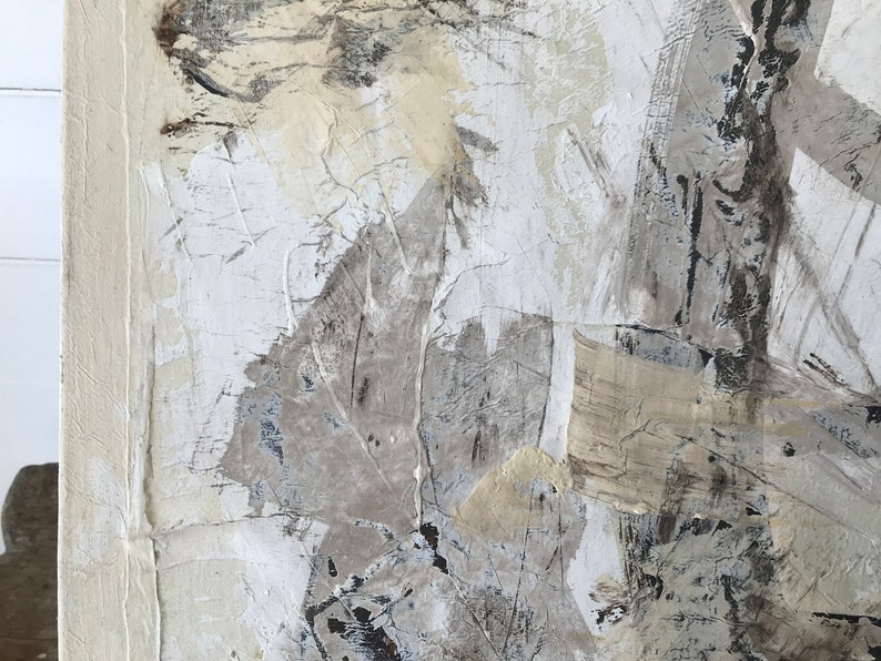 Op de afbeelding: Abstract schilderij met een textuur, gelaagde oppervlak. Het schilderij heeft tinten wit, grijs en beige met hints van zwart. De verf is aangebracht in een dikke, impasto-stijl, waardoor een driedimensionaal effect ontstaat.