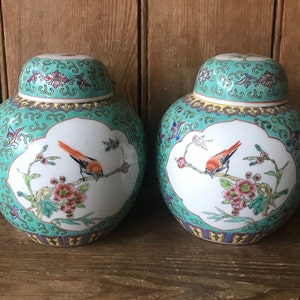 Peut inclure: Deux pots à gingembre en porcelaine chinoise vintage avec des motifs floraux verts et blancs et des oiseaux rouges. Les pots ont un design chinois traditionnel avec un couvercle.