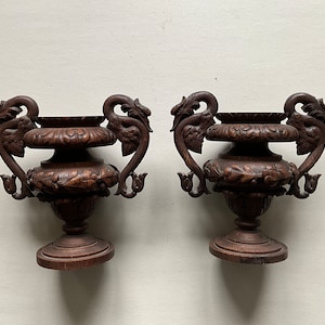 Puede incluir: Dos urnas decorativas de madera marrón oscuro con intrincados tallados de dragones y motivos florales. Las urnas tienen un diseño clásico y son perfectas para agregar un toque de elegancia a cualquier hogar.