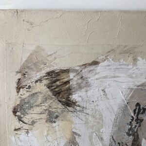 Op de afbeelding: Abstract schilderij op canvas met een textuur achtergrond. Het schilderij heeft tinten van wit, bruin en grijs in een gelaagde en abstracte stijl.
