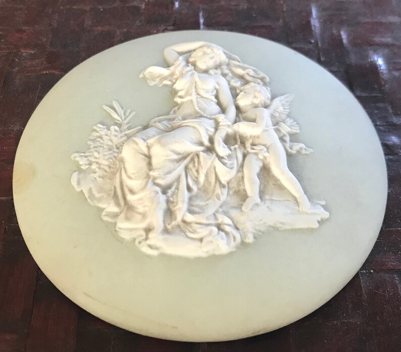 probably Wedgwood Small round green china plate with antique decor of a woman with angel