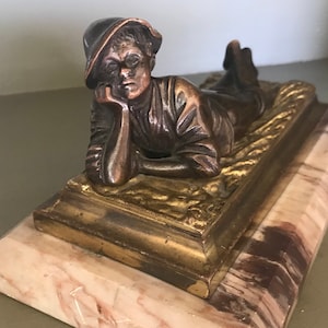 Bronze auf Marmorsockel, Junge auf einem Feld liegen