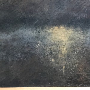 May include: A close-up of a dark gray textured surface with a light gray and white area in the center.