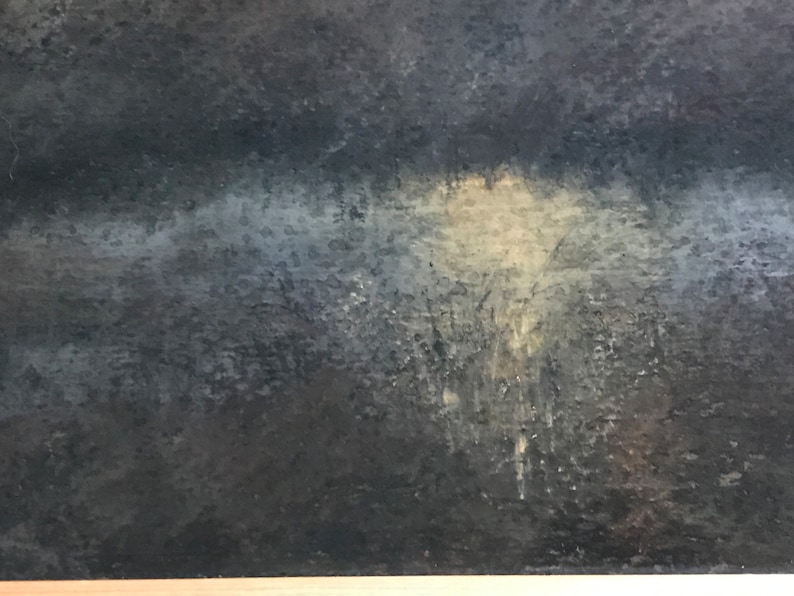 May include: A close-up of a dark gray textured surface with a light gray and white area in the center.