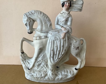 Statuette en faïence de staffordshire, 19 ème siècle, la princesse royale  Victoria  en blanc sur un cheval blanc.