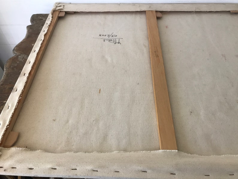 Puede incluir: La parte posterior de un lienzo estirado con barras de bastidor de madera. El lienzo es blanco y tiene una inscripci&oacute;n manuscrita que dice "50/50 2007".