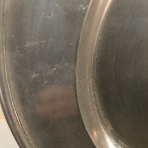 May include: Close-up of a silver metal serving tray with a smooth, slightly worn surface.