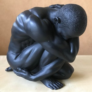 Żywiczna statuetka przedstawiająca przyczajonego mężczyznę