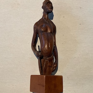 African carved wooden statuette, man up to mid-thigh, signature on the back