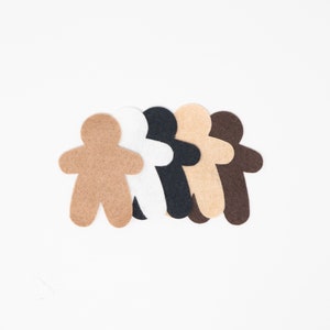 May include: Five felt cutout figures of people standing in a row. The figures are different colors: brown, white, black, tan, and dark brown.