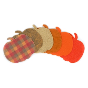 May include: A set of seven felt apple shapes in various shades of orange, brown, and red. The apples are arranged in a semi-circle, with the largest apple at the bottom and the smallest apple at the top.