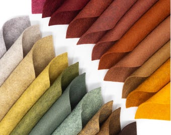 May include: A collection of felt fabric sheets in various shades of brown, yellow, green, and gray. The sheets are arranged in a fan shape, with the darkest shades at the top and the lightest shades at the bottom.