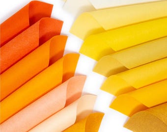 May include: A collection of felt sheets in various shades of orange and yellow, arranged in a gradient pattern. The sheets are folded and stacked, creating a visual display of color.