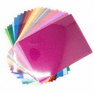 May include: A selection of glitter sheets in a range of colours, such as pink, green, blue, and silver. The sheets have a shiny, textured surface, and are arranged on a white background. Suitable for crafting and DIY projects.