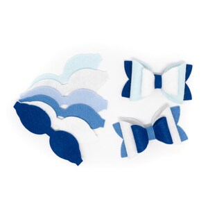 May include: A set of felt bow tie shapes in shades of blue and white. The set includes two pre-made bow ties and a stack of felt shapes for making additional bow ties.