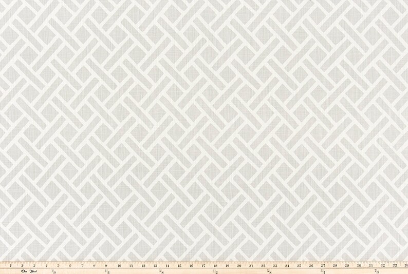 May include: White fabric with a geometric pattern of woven white lines on a light gray background. The fabric is measured in inches.