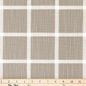 May include: Tan and white plaid fabric with a grid pattern. The fabric has a textured appearance and is measured with a ruler showing inches. The plaid design features thick white lines against a tan background.
