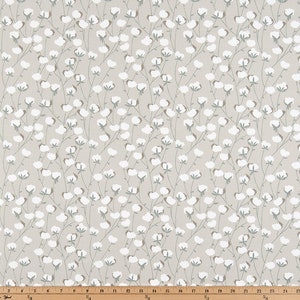 May include: A beige fabric with a repeating pattern of white cotton blossoms and green stems.