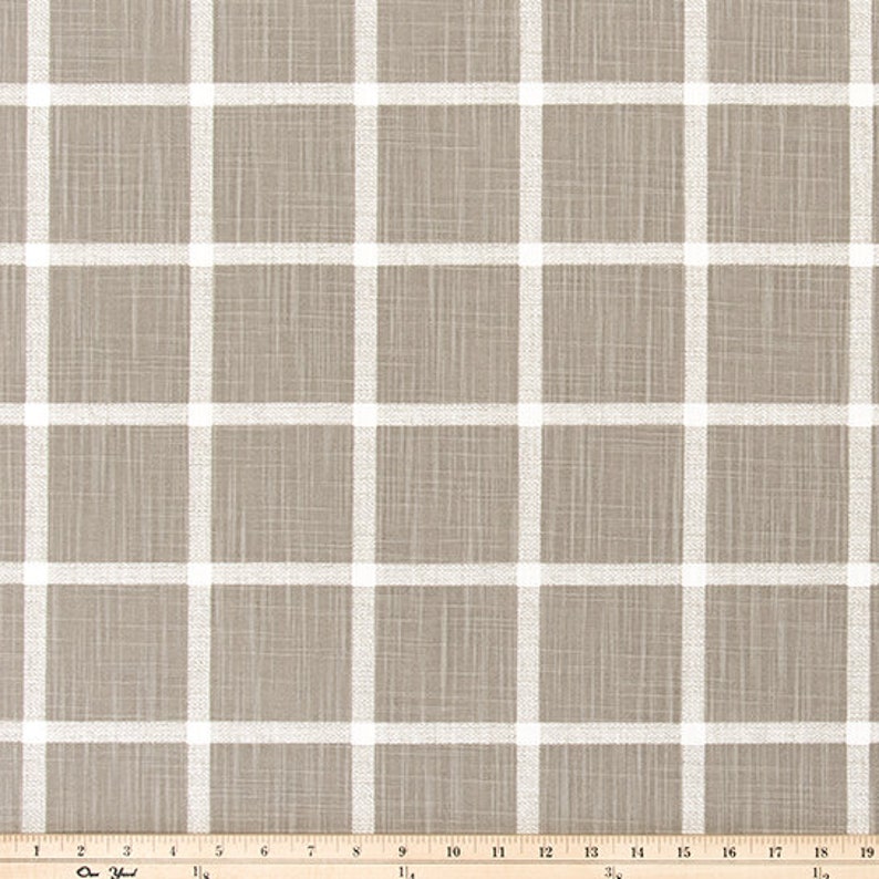 May include: A neutral-toned fabric with a grid pattern. The fabric has a light brown background with a white grid overlay. The grid lines are evenly spaced, creating a clean, modern design. Suitable for various home decor projects.