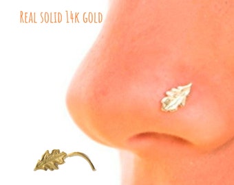 Könnte beinhalten: Ein goldener Nasenring in Blattform aus 14 Karat massivem Gold. REAL SOLID 14K GOLD steht in der oberen linken Ecke des Bildes.