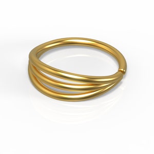 May include: A gold ring with three bands that are intertwined. The ring is smooth and shiny.