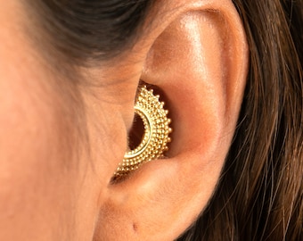 May include: Gold ear cuff with a beaded design. The cuff is worn in the upper ear, near the cartilage.