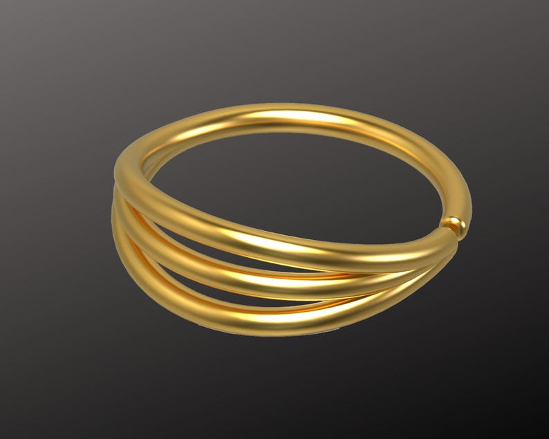 May include: A gold ring with three bands, each band is slightly offset from the others. The ring is smooth and shiny.