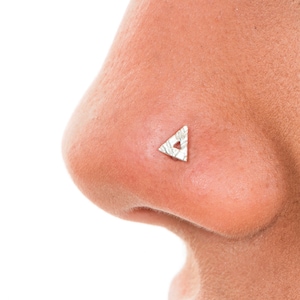 Può includere: Un anello per il naso triangolare in argento con un piccolo foro al centro.