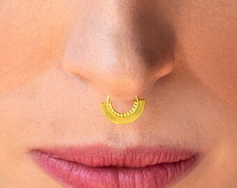 May include: A gold nose ring with a half-circle design and a beaded edge.