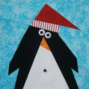 Puede incluir: Un pingüino blanco y negro con un sombrero a rayas rojas y blancas con botones blancos para los ojos. El pingüino está sobre un fondo azul con remolinos blancos.