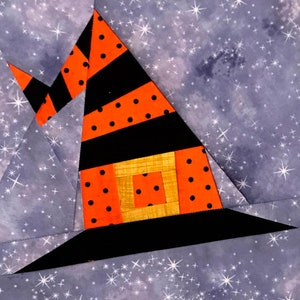May include: A witch's hat made of fabric with black and orange stripes and black polka dots. The hat is against a gray background with white stars.