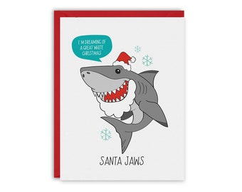 May include: A Christmas card featuring a cartoon shark wearing a Santa hat and a white beard. The text on the card reads "I'm dreaming of a great white Christmas" and "Santa Jaws".