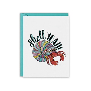 May include: A white card with a teal envelope. The card features a colorful, patterned seashell with a red hermit crab on top. The text "Shell Yeah!" is written in black above the shell.