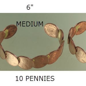 Peut inclure: Bracelets en pi&egrave;ces de monnaie de diff&eacute;rentes tailles : Extra Petit (12.1 cm), Petit (14 cm), Moyen (15.2 cm), Grand (16.5 cm) et Extra Grand (17.8 cm). Chaque bracelet est fait de pi&egrave;ces de monnaie, le nombre de pi&egrave;ces augmentant avec la taille.