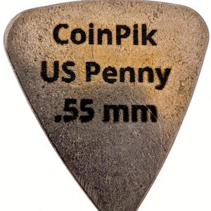K&ouml;nnte beinhalten: Ein dreieckiges Gitarrenplektrum aus einem kupferfarbenen US-Penny mit strukturierter, metallischer Oberfl&auml;che. Der Text CoinPik, US Penny und .55 mm ist schwarz auf die Vorderseite graviert und gibt Material und St&auml;rke an.