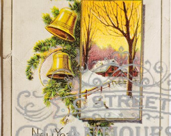 May include: Vintage New Year's Greetings postcard. The card features a winter scene with a snow-covered house and trees, framed by a gold border. Two gold bells and evergreen branches adorn the card. The words "New Year Greetings" are printed in gold.
