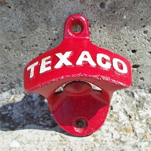 May include: Red metal bottle opener with a white "TEXACO" logo.