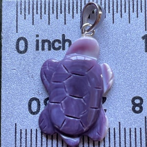May include: A purple shell turtle pendant with a silver bail. The turtle is about 1 inch in length.