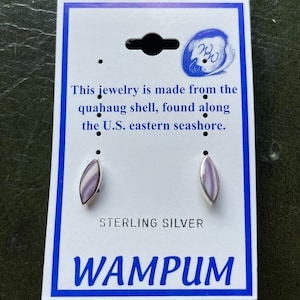 May include: A pair of sterling silver earrings with purple and white shell inlays. The earrings are displayed on a card that reads "This jewelry is made from the quahaug shell, found along the U.S. eastern seashore. Sterling Silver WAMPUM"
