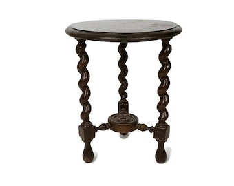 May include: A dark brown, antique side table with a round top and three spiral-turned legs. The table has a small, circular shelf connecting the legs near the base. The table is made of wood and has a glossy finish.