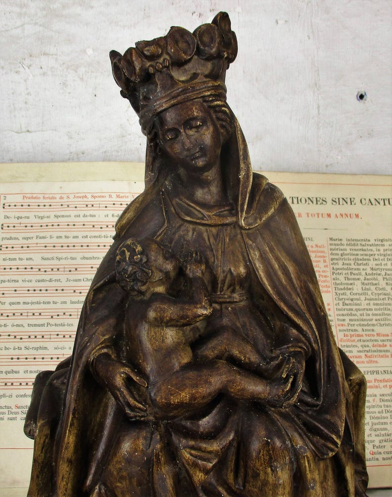 Statue Virgin Mary With Infant On her Lap against Her Chest image 0
