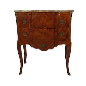 May include: A two-drawer antique chest of drawers with a marble top. The chest is made of wood with a marquetry design and has brass hardware. The chest is on four legs.