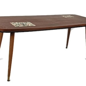 Puede incluir: Una mesa de centro de estilo moderno de mediados de siglo con una tapa de madera oscura y cuatro patas cónicas. La tapa de la mesa presenta dos diseños de azulejos incrustados.