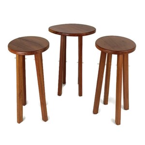May include: A set of three wooden side tables with a natural finish. Each table has a round top and three angled legs. The tables vary in size, offering a versatile set. The height is approximately 40-60 cm.