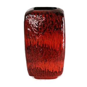 May include: A red ceramic vase with a textured, glazed finish. The vase has a square shape with rounded edges.